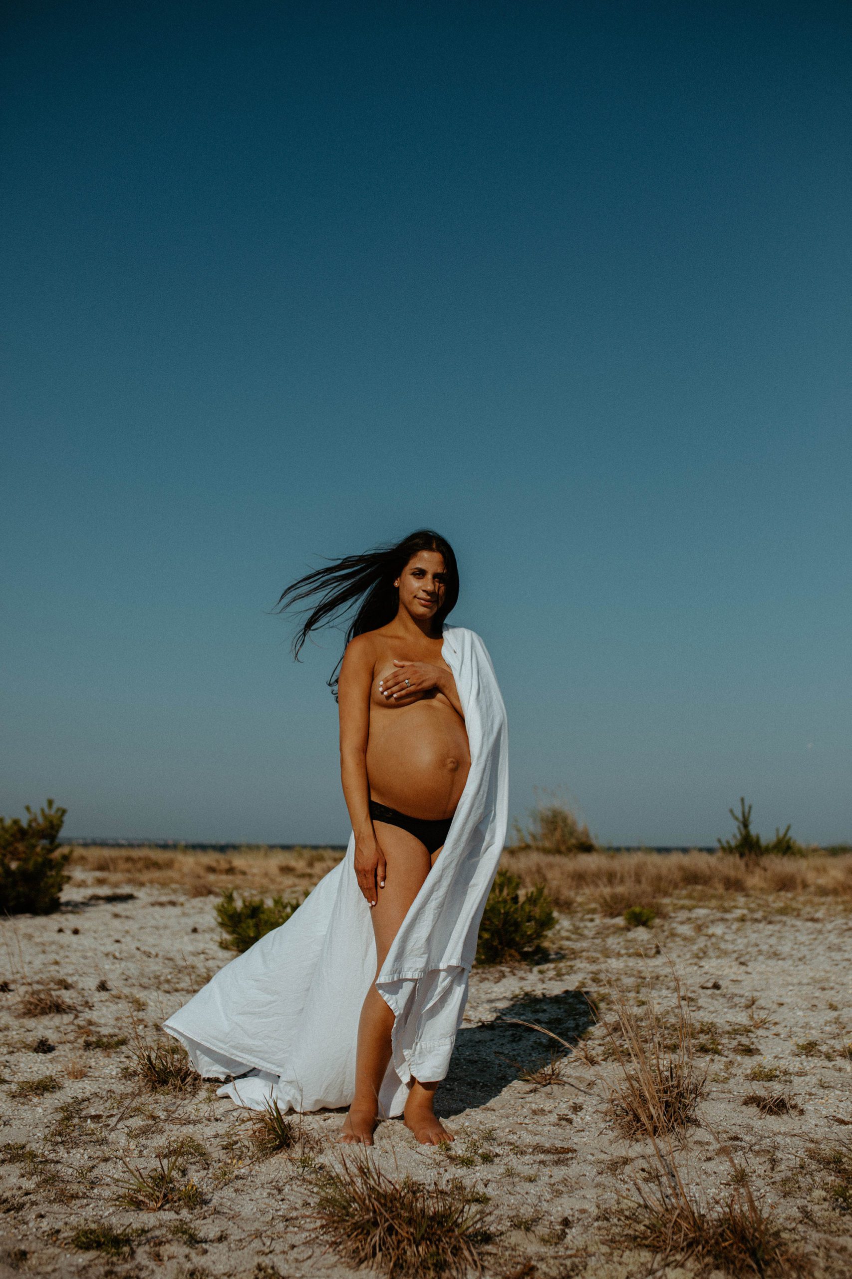 Pregnant woman desert maternity photos white sheet long hair. Beach Maternity Portraits
