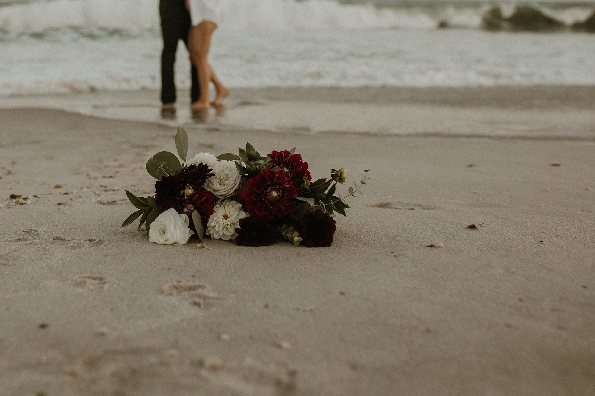 Beautiful floral bouquet laying on the sand on the beach