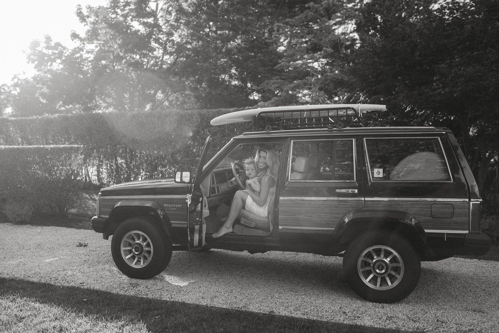 New England mom and child family portraits in the front seat of their wood paneled jeep wagoneer in the summertime, Long Island family photographer