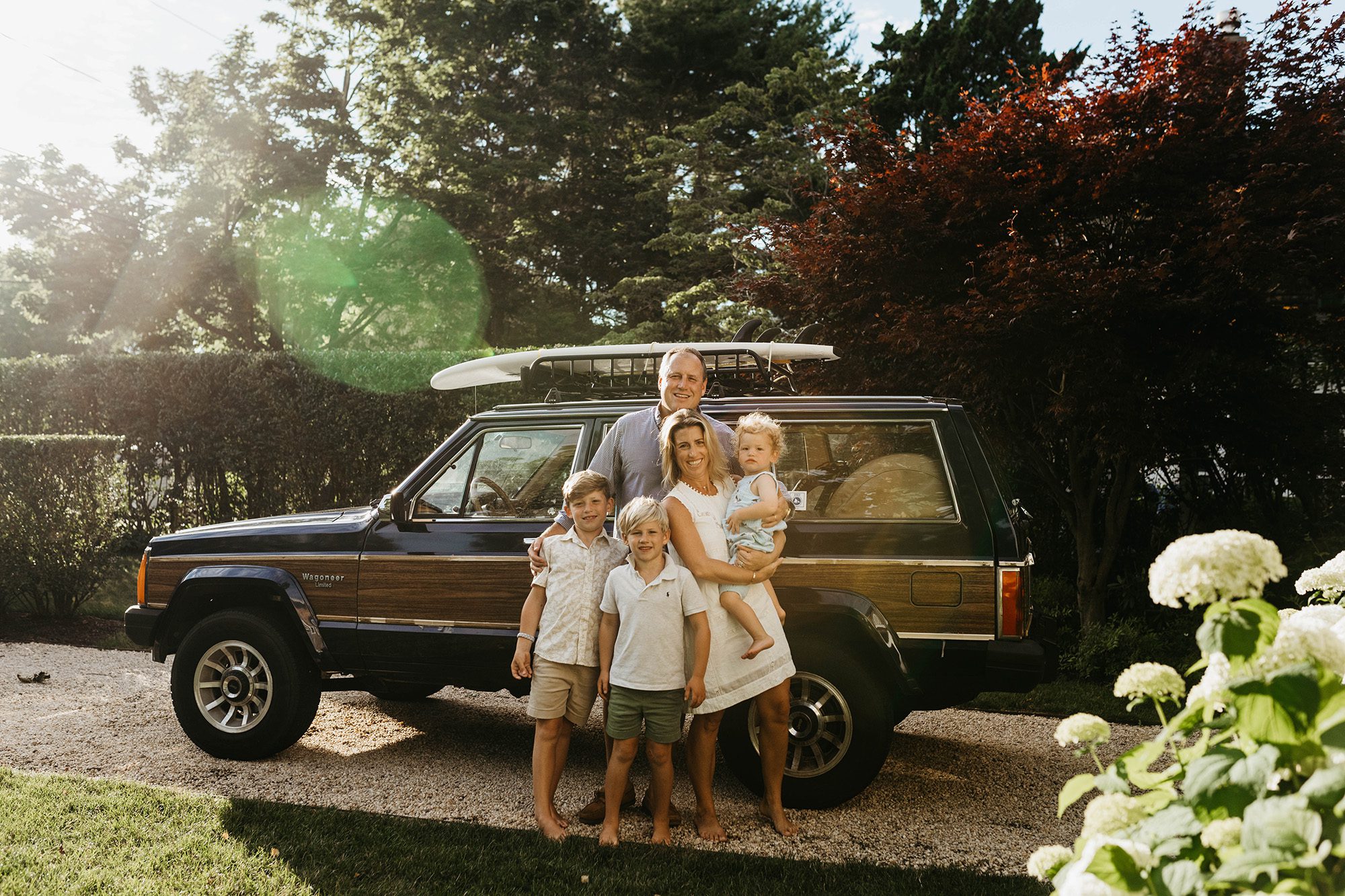 New England Family of 5 portraits in front of their wood paneled jeep wagoneer in the summertime. Long Island family photographer