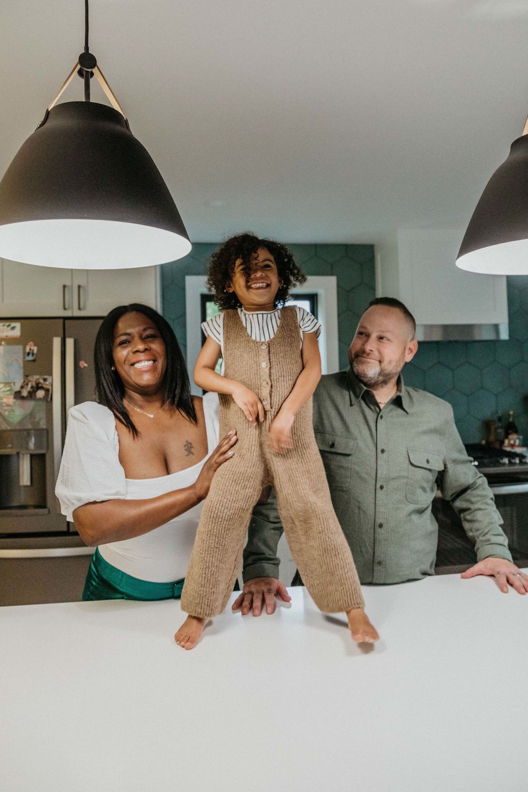 family of 3 portraits. mother father daughter kitchen photo session at home. Boston area NYC family photographer 