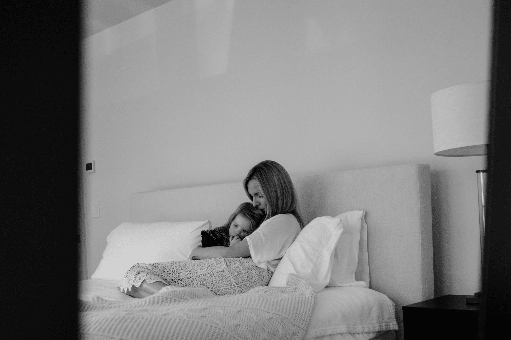 black and white mommy and me photo shoot at home by a New York family photographer neutral matching family outfits in bed 