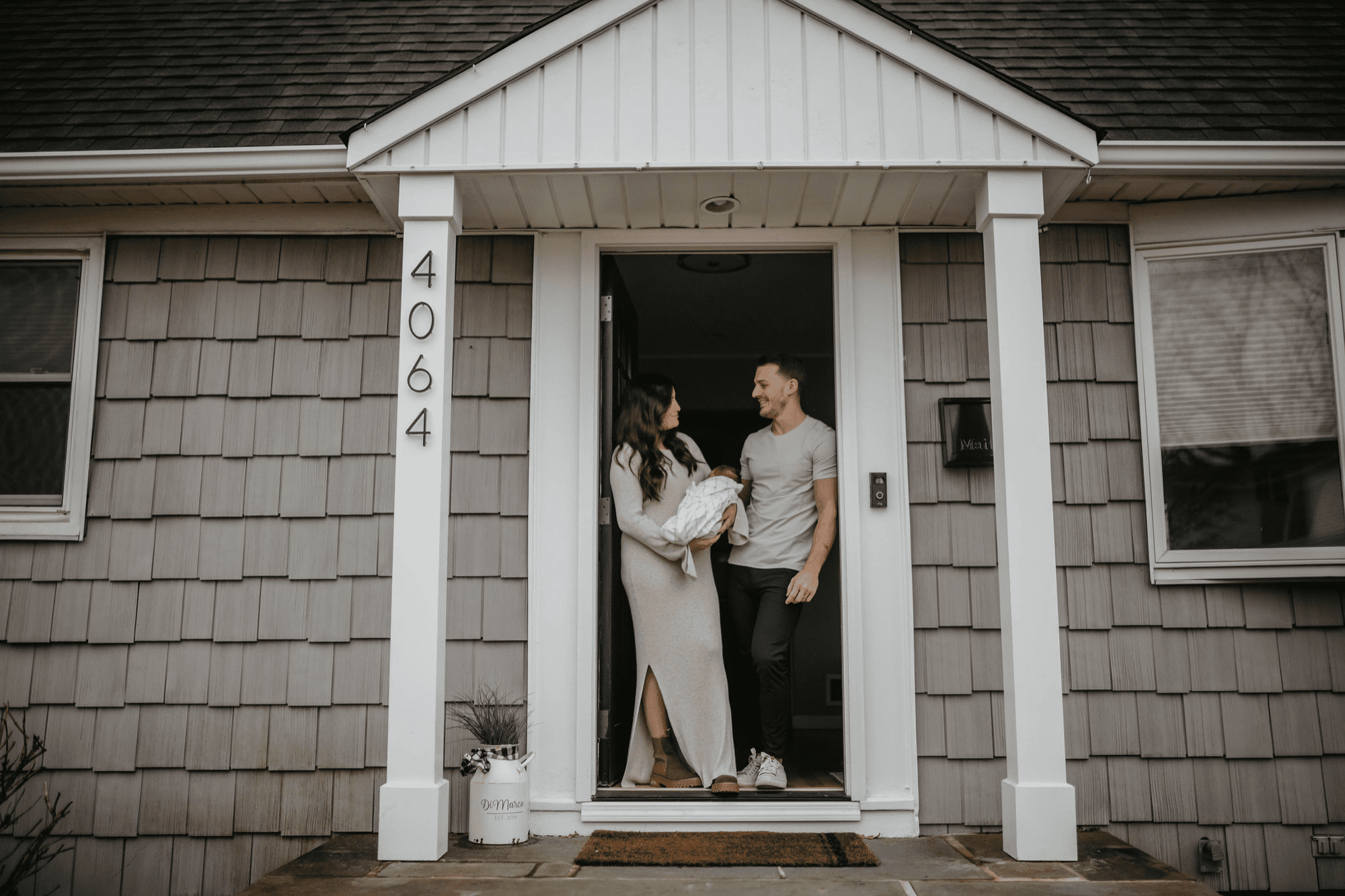 Front door family picture. At home photoshoot. In home newborn photos. Newborn photoshoot. Neutral color family photos. long island maternity photographers. Maternity photography near me